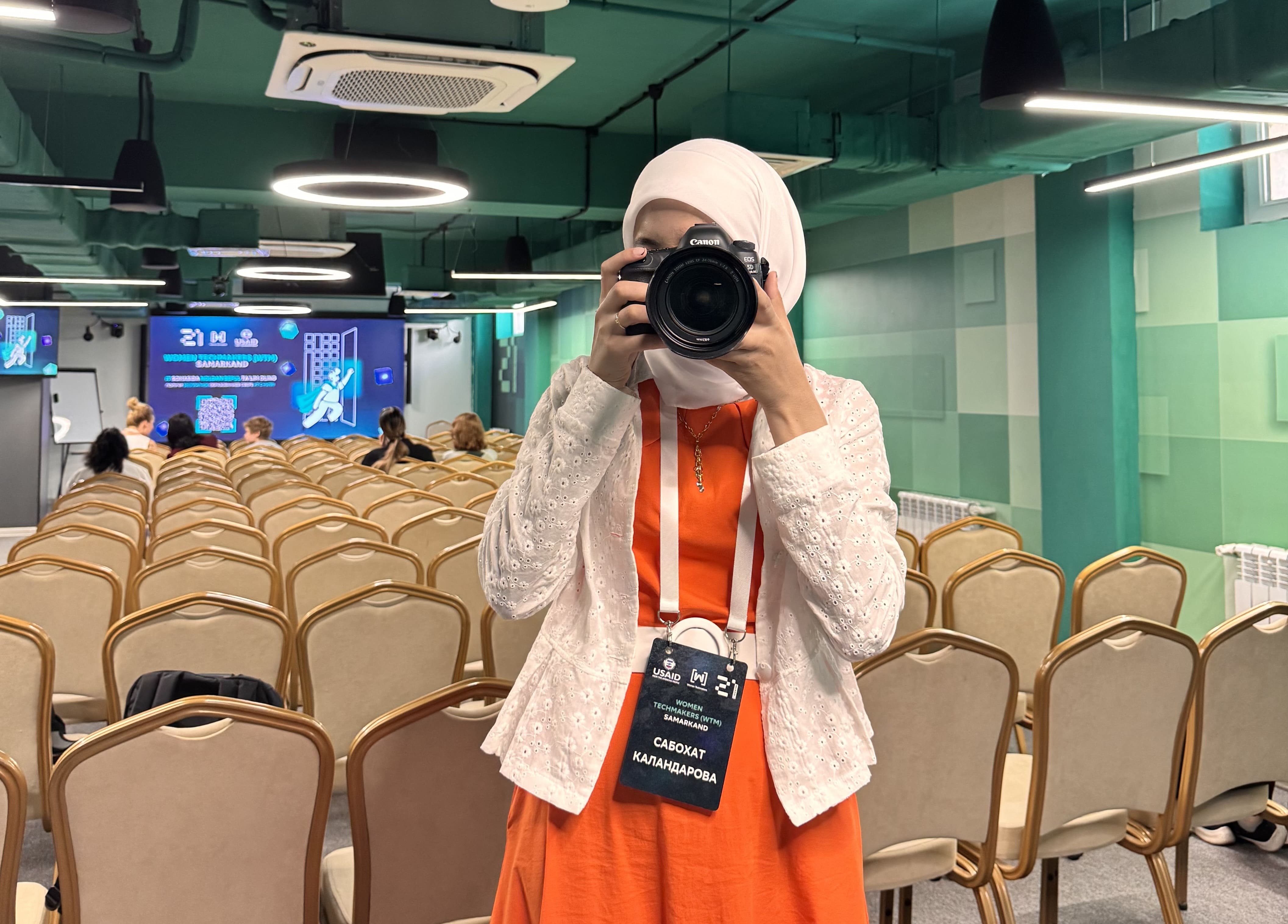 Sabokhat Kalandarova holding a camera at Samarkand IT festival